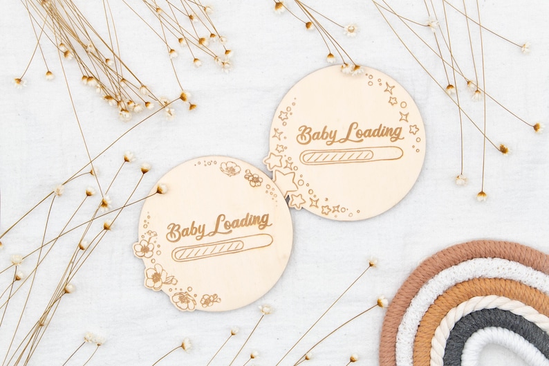 May include: Two round wooden signs with the text "Baby Loading" and a progress bar. The signs are decorated with small stars and flowers.