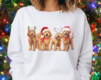 May include: White sweatshirt with a graphic of four doodle dogs wearing Santa hats and reindeer antlers. The dogs are brown and white with red and green scarves.