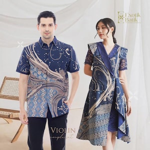 Puede incluir: Conjunto a juego para parejas, compuesto por una camisa de manga corta y un vestido azul marino. Ambas prendas presentan un diseño batik con patrones arremolinados en tonos azules, beige y blancos. El texto "VIOLIN couple set" es visible.