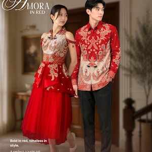 Pode incluir: Um vestido vermelho sem mangas com gola alta e bordados dourados e brancos, combinado com uma camisa vermelha de manga comprida com padrão floral dourado e branco a condizer e calças pretas. O texto diz Amora in red.