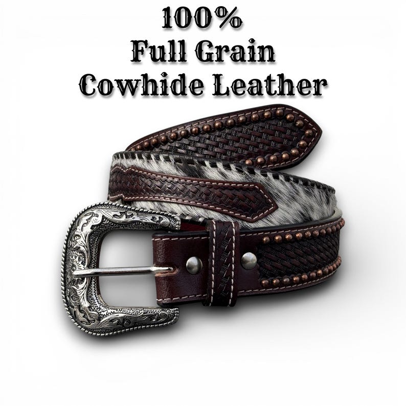 May include: A brown leather belt with a silver buckle. The belt features a woven design, studded accents, and a section of cowhide with black and white fur. The text "100% Full Grain Cowhide Leather" is at the top.