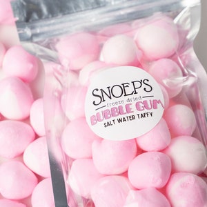 May include: A bag of pink freeze-dried bubble gum salt water taffy. The bag is labeled "Snoep's Freeze Dried Bubble Gum Salt Water Taffy".