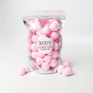 May include: A clear plastic bag filled with pink and white bubble gum. The bag has a white label with the text "Snoep's - freeze dried - Bubble Gum - Salt Water Taffy".