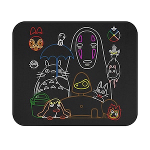 May include: A black mousepad with a colorful outline drawing of characters from the animated film Spirited Away. The characters include No Face, Totoro, and a cat bus.