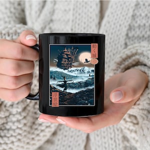 May include: Black ceramic mug with a graphic of a flying airship, a person in a dress, and Japanese text that reads "Moving Castle".