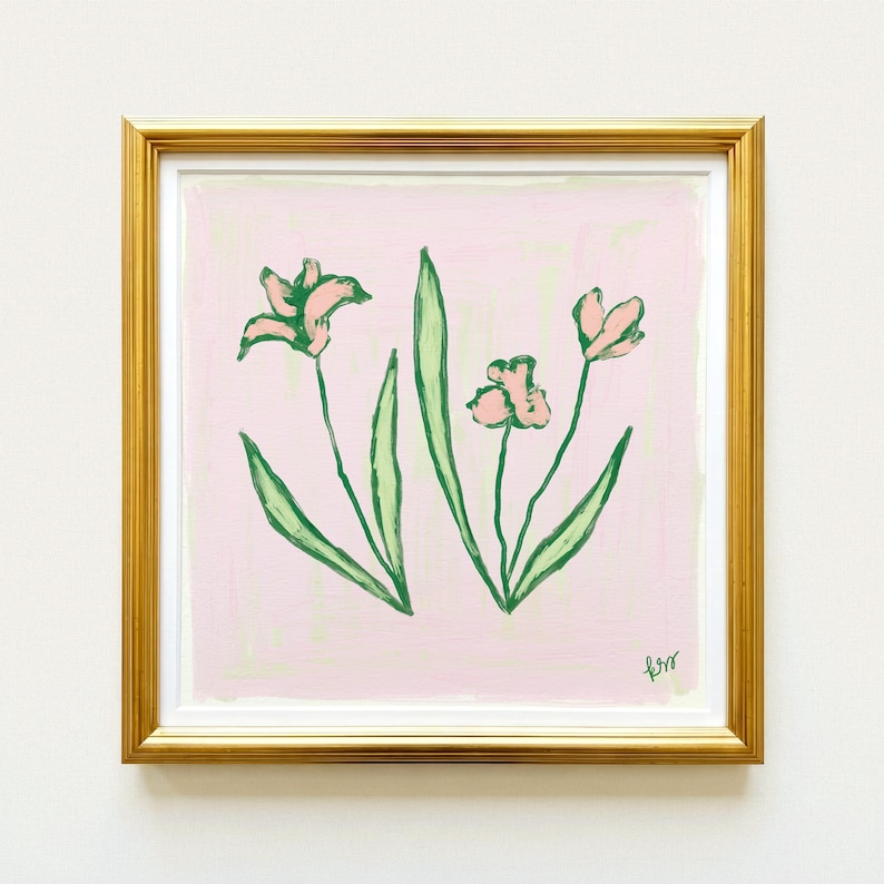 The image is a framed painting of two pink flowers with green leaves, displayed on a white wall.