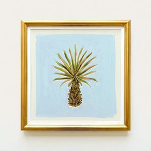 The image is a framed painting of a palm tree with a green and brown color palette.