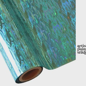 May include: A roll of iridescent teal film featuring a wavy, liquid-like pattern that reflects light with holographic blue and green tones. The text artistic painting studio is printed in black on the right side of the image.