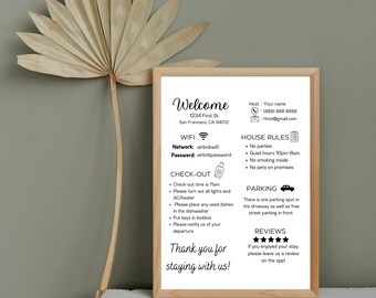 May include: A white welcome sign with black text and icons. The sign includes information about WiFi, check-out time, house rules, parking, and reviews. The text includes the address 1234 First St, San Francisco, CA 94012.