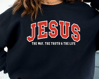 May include: Black sweatshirt with the word "JESUS" in red block letters with a white outline. Below the word "JESUS" is the text "THE WAY. THE TRUTH & THE LIFE" in white letters. The sweatshirt is a crew neck style.