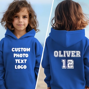Puede incluir: Una sudadera con capucha azul real con un bolsillo delantero y capucha. La parte delantera de la sudadera tiene las palabras "CUSTOM PHOTO TEXT LOGO" en blanco. La parte trasera de la sudadera tiene el nombre "OLIVER" y el n&uacute;mero "12" en blanco.