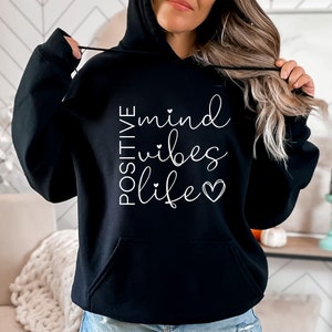 May include: Black hooded sweatshirt with white text that reads "POSITIVE mind vibes life" with a small heart symbol.