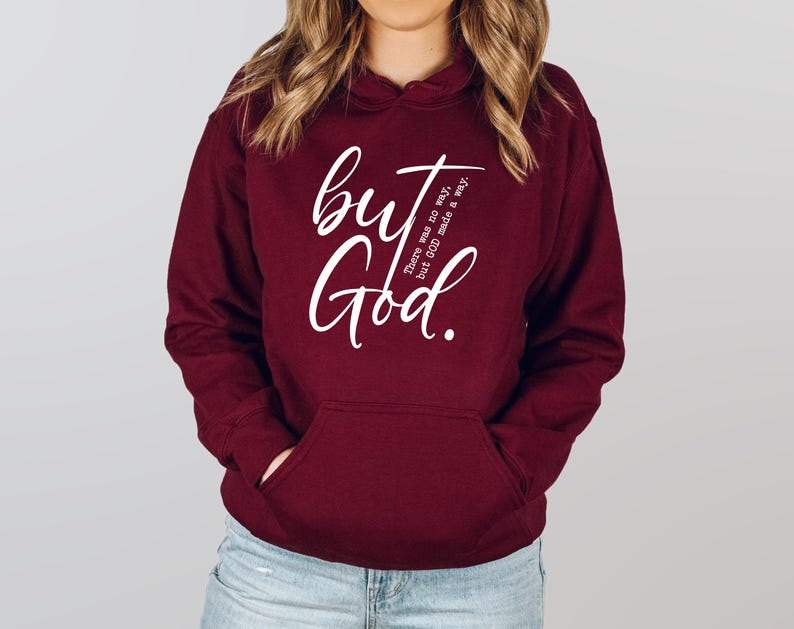 May include: A maroon hoodie with a front pocket and a hood. The hoodie features the white text "but God" in a cursive font, with the phrase "There was no way, but GOD made a way." printed vertically on the right side.