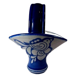 May include: A small blue and white ceramic basket with a handle. The basket is decorated with a white bird and floral design.