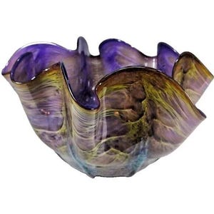 May include: A decorative glass bowl with a wavy, organic shape. The bowl features a blend of colors, including shades of purple, brown, and yellow, creating a marbled effect. The rim has a ruffled edge, adding to its unique design.