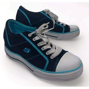 May include: A pair of black canvas sneakers with blue trim and white soles. The sneakers have a lace-up closure and a blue 'S' logo on the side.