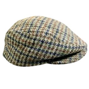May include: A flat cap featuring a multi-colored houndstooth pattern in shades of brown, tan, navy blue, and olive green. The cap has a rounded, structured crown and a short, stiff brim integrated into the front of the headwear design.