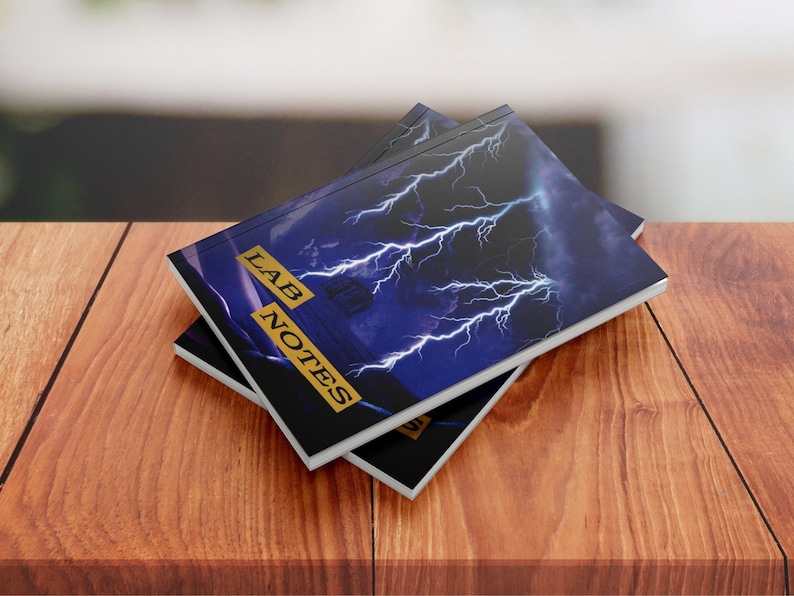 May include: Two black and white notebooks with a blue and white lightning bolt design on the cover. The cover text reads "LAB NOTES".