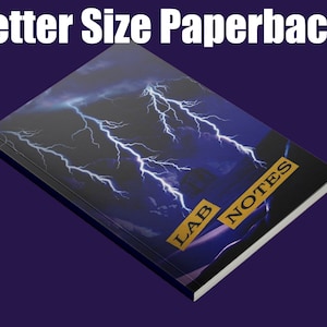 May include: A paperback notebook with a black cover featuring a lightning bolt design and the text "LAB NOTES" in gold lettering.