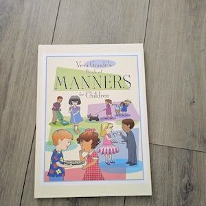 Könnte beinhalten: Ein Softcover-Buch mit dem Titel Vera Goode's Book of Manners for Children. Das Cover zeigt eine bunte Illustration von Kindern, die verschiedene höfliche Aktivitäten ausführen, darunter Putzen, Gassi gehen und Tee servieren.
