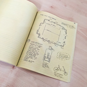 May include: Hand-drawn sketch of a building plan with measurements in feet, a diagram of a water tank, and a drawing of a recumbent bicycle labeled "Sun Tomahawk" with a black frame and grey wheels.