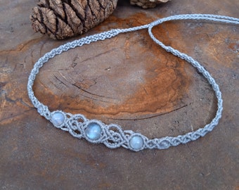May include: A gray macrame necklace with four light blue moonstone beads.