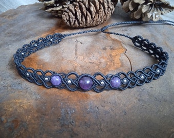 Puede incluir: Un collar gargantilla de macramé negro con piedras preciosas de amatista y cuentas plateadas.