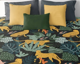 May include: A bed with a black patterned comforter featuring yellow leopards, green foliage, and blue accents. The bed is adorned with gray, yellow, and green pillows. The room has wooden nightstands, a white shelf, and decorative plants.
