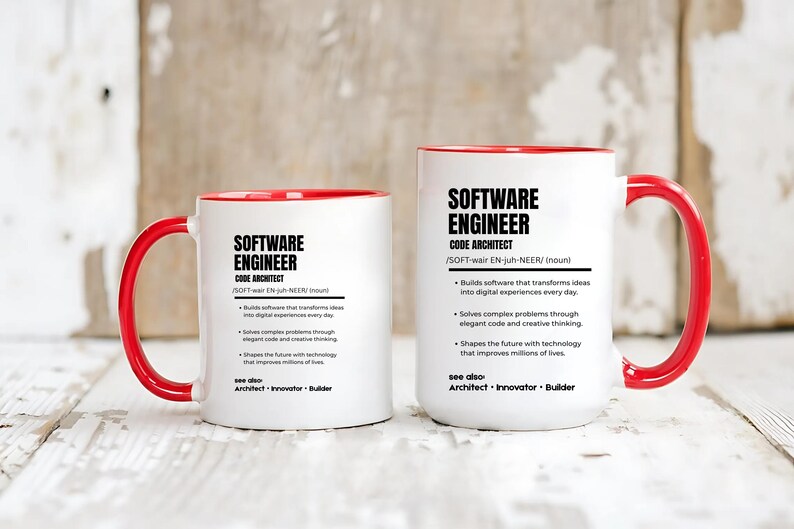 K&ouml;nnte beinhalten: Zwei wei&szlig;e Keramikbecher mit leuchtend roten Henkeln und Innenseiten. Jeder Becher ist mit schwarzem Text bedruckt, der einen Softwareentwickler als Code-Architekten definiert, inklusive Lautschrift und stichpunktartigen Aufgaben.