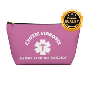Puede incluir: Bolsa rosa con cremallera con un símbolo blanco de estrella de la vida y el texto "CYSTIC FIBROSIS EMERGENCY LIFE SAVING MEDICINES INSIDE".