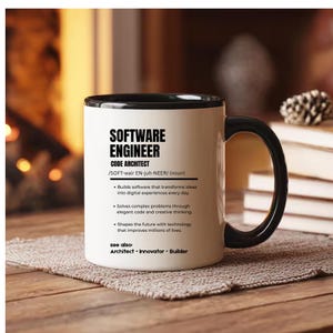 K&ouml;nnte beinhalten: Ein wei&szlig;er Keramikbecher mit schwarzem Innenraum und Henkel, bedruckt mit schwarzem Text, der einen Softwareentwickler als Code-Architekten definiert, der Software erstellt, komplexe Probleme l&ouml;st und die Zukunft mit Technologie gestaltet.