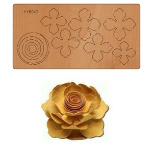 May include: A die-cut template for crafting a paper flower. The template includes six flower petals and a spiral centre. The template is made of brown wood and has the code YY8043 printed on it. A finished paper flower is shown below the template.