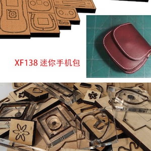 May include: A set of clear plastic leather craft cutting dies with various shapes, including a heart, flower, and a rectangle. The dies are arranged on a brown surface. The text "XF138  Leather Craft Cutting Dies" is visible in the image.