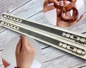 May include: Two wooden leather stamping tools with a grooved surface and multiple holes. The tools are used to create a braided leather bracelet. The bracelet is brown leather with a metal buckle.