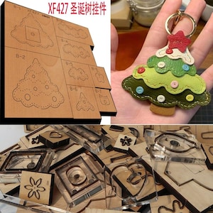 Könnte beinhalten: Ein Satz Leder-Stanzformen zum Herstellen eines Weihnachtsbaumschmucks. Die Formen sind aus Holz und Metall und in verschiedenen Größen erhältlich. Die Formen sind auf einer Holzoberfläche mit einem fertigen Leder-Anhänger im Hintergrund abgebildet.