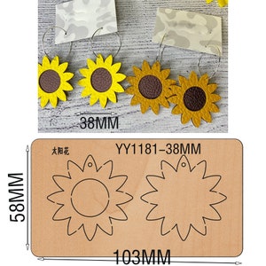 May include: A set of two leather sunflower earrings with a brown center and a yellow outer layer. The earrings are 38 mm in diameter and are shown on a wooden cutting board with the text "YY1181-38MM" and "58MM" printed on the board. The cutting board also shows two sunflower shapes with a hole in the center, which are 103 mm in diameter.