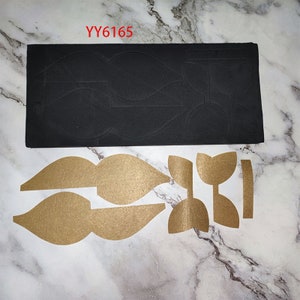 May include: A black foam die-cutting template with the text "YY6165" and a set of brown paper cut-outs of bow shapes.