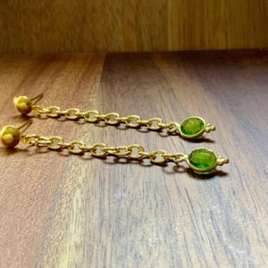 Long, round, lightweight, delicate, simple, chain-style drop earrings with green peridot and black onyx. Features a chain design, trendy style, and a dangling effect.
