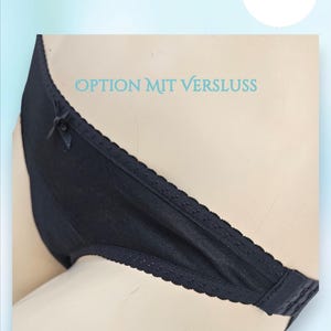 Pode incluir: Calcinha preta com acabamento em renda e detalhe de laço. A calcinha tem o texto "OPTION MIT VERSCHLUSS" impresso na cintura.