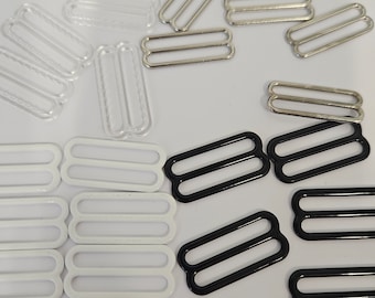 May include: Assortment of metal bra strap sliders in clear, white, black, and silver. The sliders are double-looped and come in various sizes.