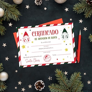 Puede incluir: Un certificado navideño con ilustraciones de elfos y rayas rojas, verdes y blancas. El texto dice "CERTIFICADO DE ADOPCIÓN DE ELFOS" y está firmado por Papá Noel. Un bolígrafo rojo descansa sobre un fondo oscuro con adornos festivos.