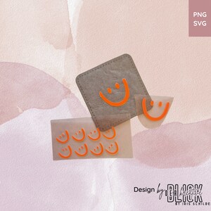 Op de afbeelding: Een set met oranje smiley-stickers op een lichtbruine achtergrond. De stickers zijn in verschillende maten en vormen. De tekst "Design by BLICK creative BY IRIS SCHILDER" staat onderaan de afbeelding.