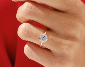 May include: A gold ring with a large, round, clear diamond set in the center.