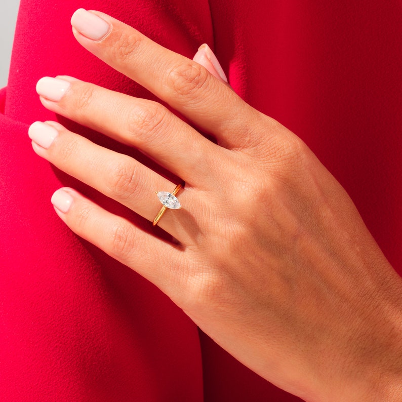May include: A gold ring with a marquise-shaped diamond set in the center.