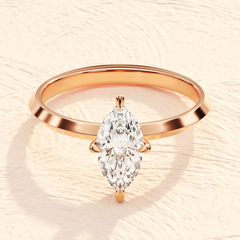 May include: A rose gold engagement ring with a pear-shaped diamond.