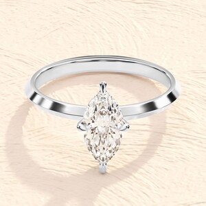 May include: A silver engagement ring with a pear-shaped diamond.