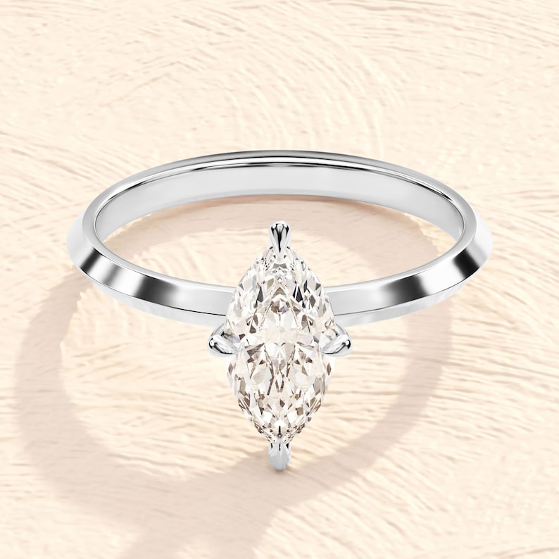 May include: A silver engagement ring with a pear-shaped diamond.