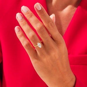 May include: A gold ring with a marquise-shaped diamond set in the center.