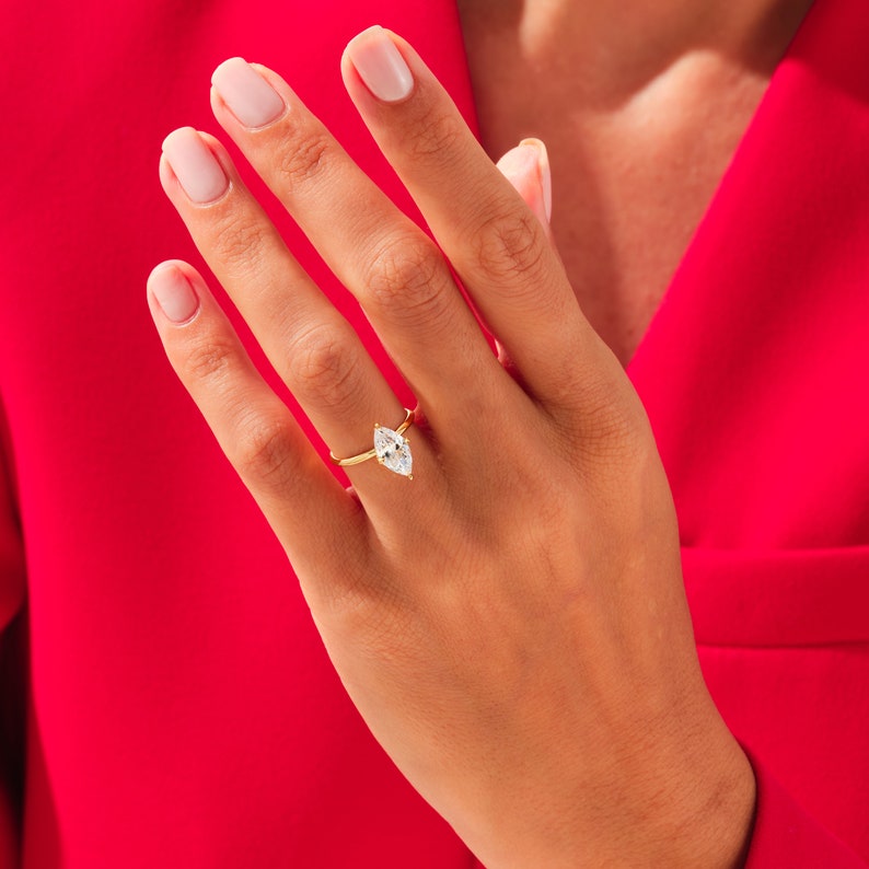 May include: A gold ring with a marquise-shaped diamond set in the center.