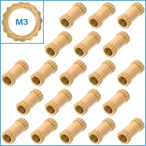 Puede incluir: Veinte insertos roscados de latón, cada uno con un borde exterior moleteado y un agujero interior roscado. Los insertos están dispuestos en una cuadrícula sobre un fondo blanco. El texto "M3" es visible en la esquina superior izquierda de la imagen.